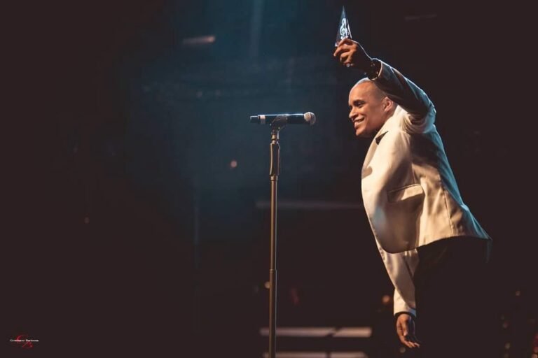 Cantor Djodje em concerto 'Sold Out', destacando a energia do palco e a interação com os fãs.