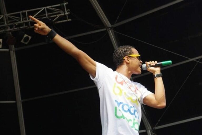 Cantor Djodje em concerto 'Sold Out', destacando a energia do palco e a interação com os fãs.